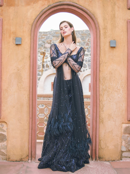Woman in a dark blue evening gown standing in front of an archway.